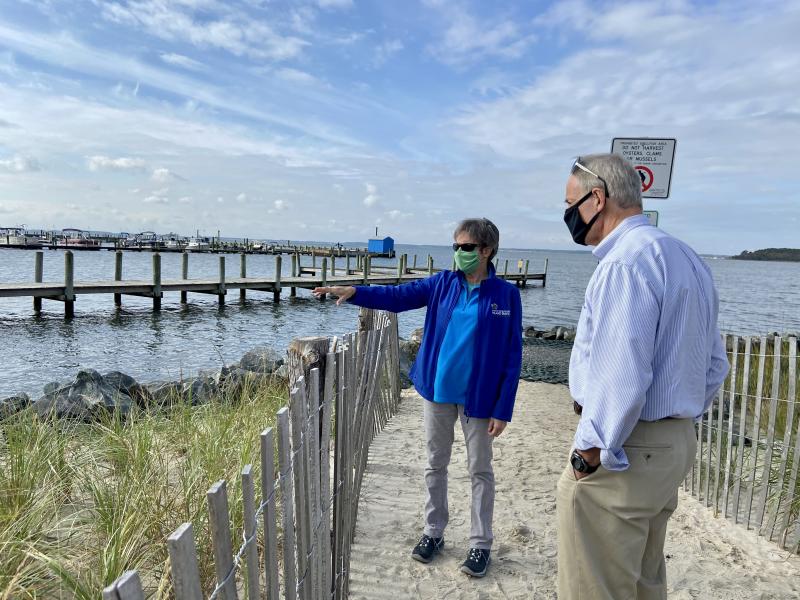 Delaware Center for the Inland Bays Science and Restoration Coordinator Marianne Walch explains to U.S. Sen. Tom Carper how tide gate valves close during high tides, preventing backflow of bay water into the storm drain system, and reducing flooding at Read Avenue bayside in Dewey Beach. ELLEN DRISCOLL PHOTO